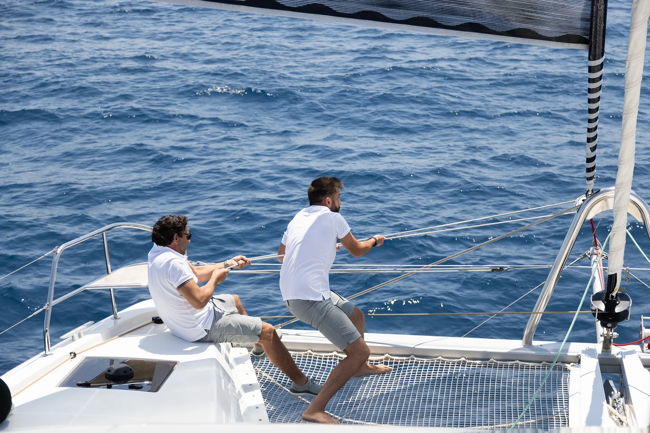 crew working the sails on a private sailing experience