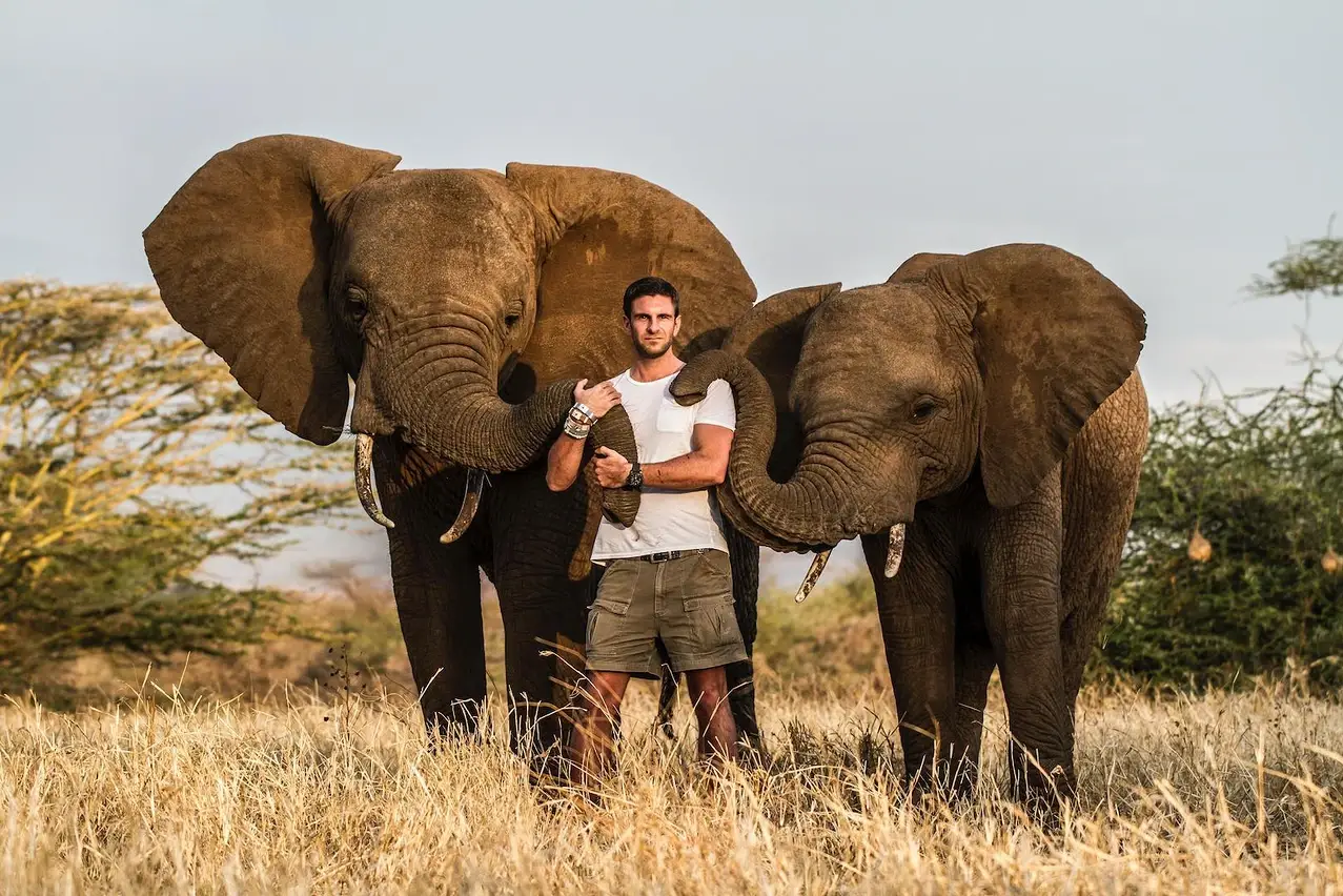 Iver rosenkrantz standing between 2 elephants